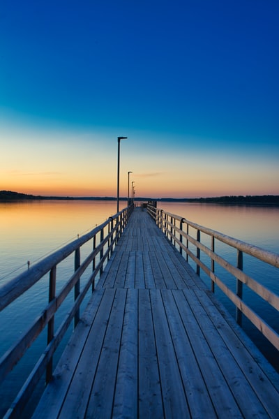 At sunset on the sea brown wooden pier
